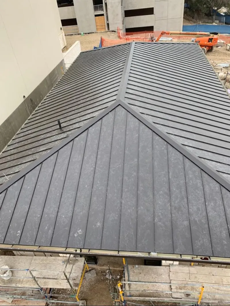 Commercial metal roof construction with crane equipment in Vergennes